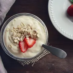 Jogurt naturalny dla niemowlaka z płatkami owsianymi i truskawkami. Pyszne i zdrowe śniadanie.