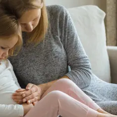 Mama pociesza córkę, która czuje się źle. Czy podczas odrobaczania dziecko może chodzić do przedszkola?